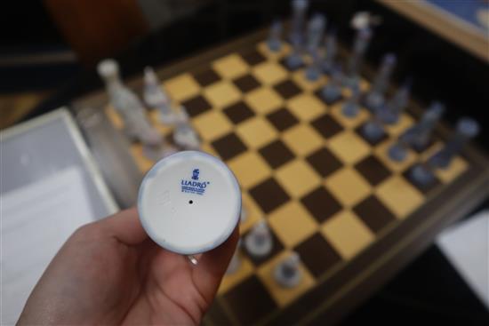 A Lladro chess set, 32 pieces, in medieval style with wooden inlaid board